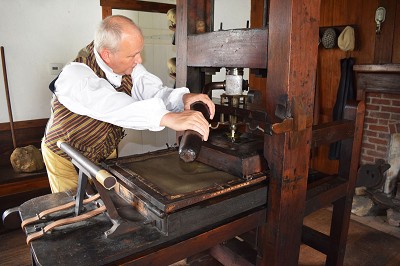 Richard Day demonstrates how Indiana's first newspaper was printed in the Elihu Stout Print Shop at the Vincennes State Historic Sites. Photo: Jess Cohen 