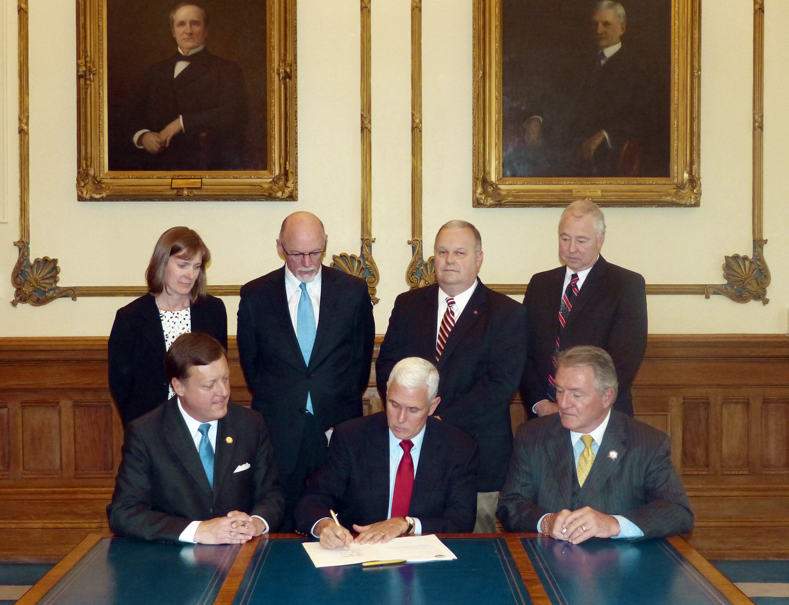 Gov. Mike Pence, center, signs HEA 1009 into law on April 22, 2014, as lawmakers and Steve Key, HSPA executive director and general counsel, back right, look on. HEA 1009, the Indiana Privacy Protection Act, prohibits warrantless searches of electronic communications, user data and geolocation information, put limits upon use of tracking devices, surveillance cameras and drones and prohibit warrantless searches using these technologies. 